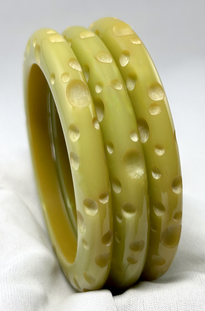 AB141 crater carved pale green bakelite bangles